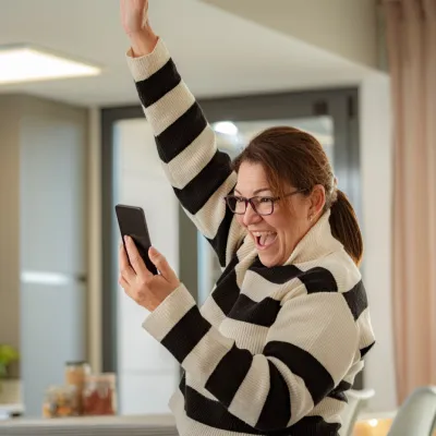 Image of lady celebrating whilst looking at her mobile phone