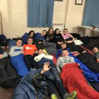 Group of young people on the floor in sleeping bags